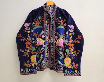May include: A navy blue jacket with colorful floral embroidery. The jacket features a mandarin collar and is adorned with pink, yellow, orange, and green floral patterns. The text "Saymataxtile" is visible on the jacket.