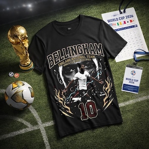 Puede incluir: Camiseta negra con un gráfico de un jugador de fútbol, el nombre "Bellingham" y el texto "England National Team World Cup 2026 Qualified". Incluye un balón de fútbol, un trofeo y una insignia de la Copa del Mundo 2026.