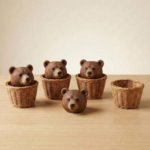 May include: Several brown bear heads are displayed, emerging from small, woven wicker baskets. One bear head is separate. The bears have detailed fur and realistic features. The baskets are light brown and have a woven texture.