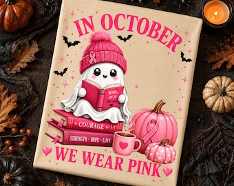 Puede incluir: Un estampado sobre tela beige que muestra un fantasma con un gorro rosa y un lazo, leyendo un libro titulado Books Are My Therapy. Debajo hay libros con las palabras Courage, Strength, Hope, Love, una taza rosa y calabazas con lazos rosas.