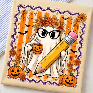 May include: A cream-colored t-shirt featuring a graphic of a ghost wearing a flower crown and black glasses, holding a jack-o'-lantern mug and a large yellow pencil. The design includes orange stripes, spiderwebs, bats, and pumpkins.