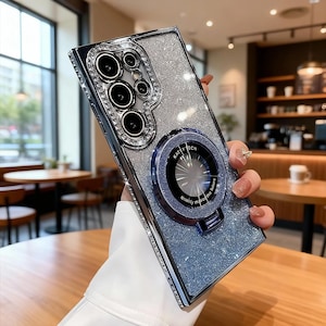 May include: A white ceramic mug with a black handle and the text "But First, Coffee" in a bold, black font. The mug is set against a blurred background, suggesting a cozy setting.