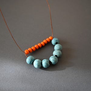 Clay rustic necklace composed of ceramic beads in light blue and terracotta, orange wooden beads and brown cotton cord .
A simple necklace in a rich color that will give on your everyday outfit style and mood.
The slip knot allows you to customize the length each time you wear it.