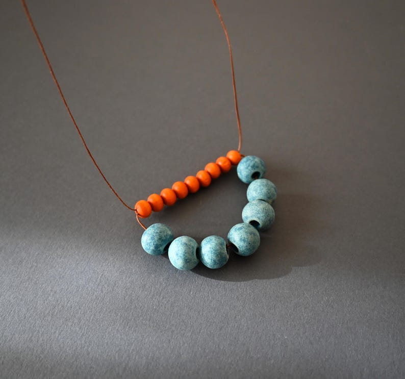 Clay rustic necklace composed of ceramic beads in light blue and terracotta, orange wooden beads and brown cotton cord .
A simple necklace in a rich color that will give on your everyday outfit style and mood.
The slip knot allows you to customize the length each time you wear it.
