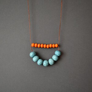 Clay rustic necklace composed of ceramic beads in light blue and terracotta, orange wooden beads and brown cotton cord .
A simple necklace in a rich color that will give on your everyday outfit style and mood.
The slip knot allows you to customize the length each time you wear it.