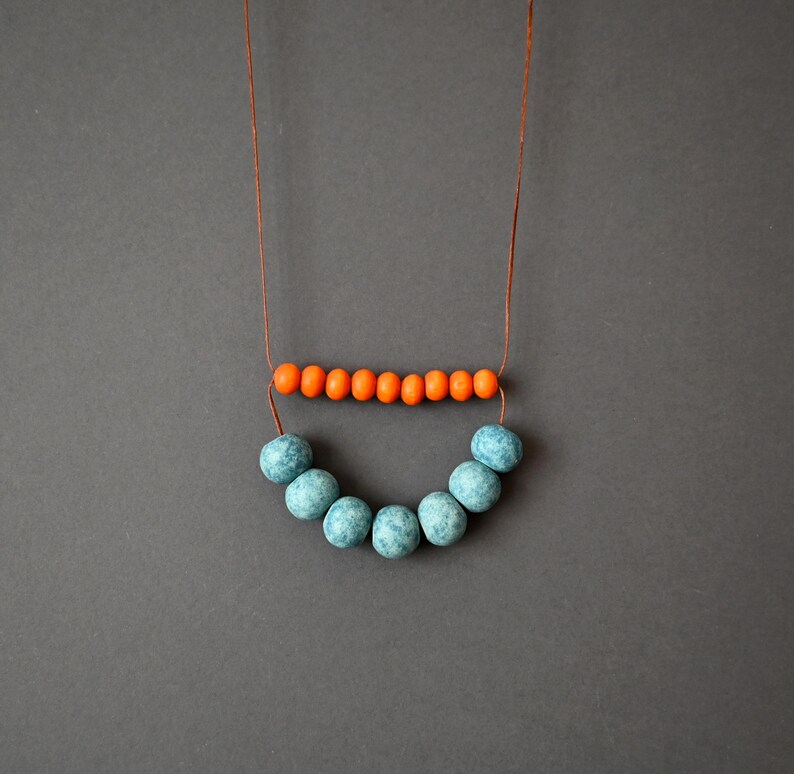 Clay rustic necklace composed of ceramic beads in light blue and terracotta, orange wooden beads and brown cotton cord .
A simple necklace in a rich color that will give on your everyday outfit style and mood.
The slip knot allows you to customize the length each time you wear it.