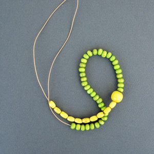 Long beaded wooden necklace in yellow and green with  adjustable cord