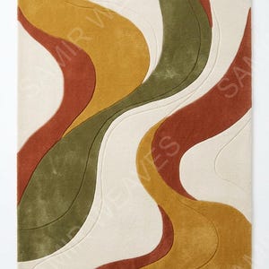 May include: A rectangular area rug featuring a series of flowing, organic wave patterns in shades of mustard yellow, olive green, and terracotta orange against a cream-colored background. The text SAMIR WEAVES is visible across the surface.
