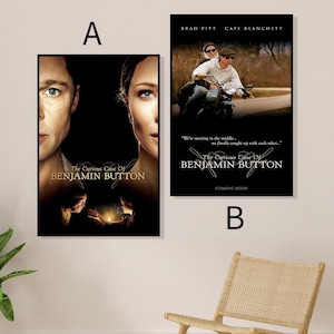 Op de afbeelding: Twee ingelijste filmposters voor "The Curious Case of Benjamin Button". Eén poster toont de gezichten van Brad Pitt en Cate Blanchett. De andere toont hen op een motor. Beide posters tonen de titel van de film.