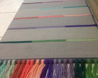 Alfombra de lana tejida a mano, color gris con rayas de colores.