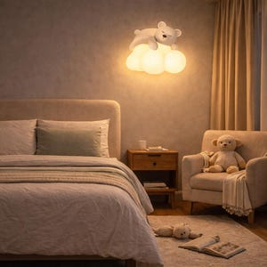 Peut inclure: Une chambre avec un lit, une table de chevet et un fauteuil. Une applique murale en forme d'ours en peluche est fixée au mur. Un ours en peluche est assis dans le fauteuil et un autre est sur le tapis.