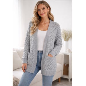May include: A light gray open-front cardigan sweater with a textured knit pattern. The sweater has two front pockets and a ribbed hem and cuffs. The model is wearing a white tank top and blue jeans.
