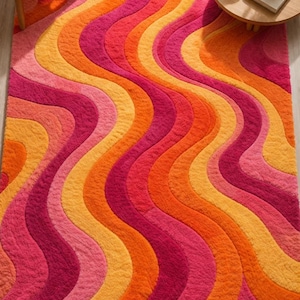 May include: A rectangular area rug featuring a repeating pattern of vertical wavy lines in vibrant shades of hot pink, bright orange, and golden yellow. The rug has a thick, textured pile surface and displays the Loom and Knot logo in the corner.