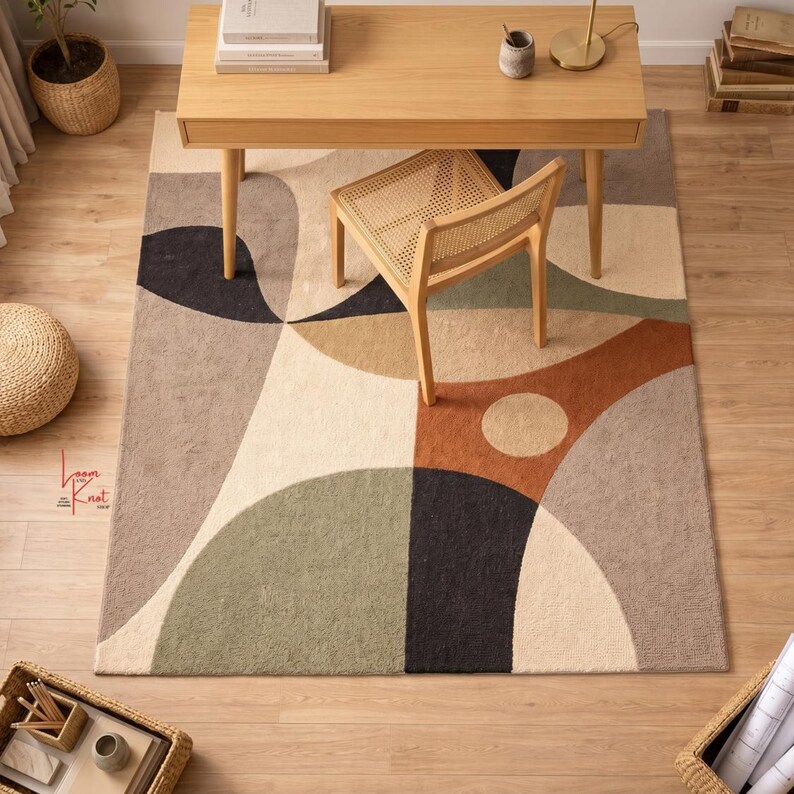May include: A rectangular area rug featuring a geometric pattern of overlapping circles and arcs in shades of beige, sage green, terracotta, and black. The rug has a textured pile surface and displays the red text Loom and Knot on the left side.