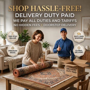 May include: A person in a beige sweater unrolling a patterned rug with orange, blue, and cream tones on a wooden table. A person in a blue shirt stands nearby next to a cardboard box labeled LoomandKnotShop Delivery Duty Paid. Text overlays include Shop Hassle-Free, Delivery Duty Paid, Top Etsy Seller, Premium Wool, Duty Paid Shipping, and Global Delivery.