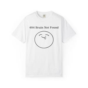 Peut inclure: Une tasse en céramique blanche avec une anse noire et le texte "But First, Coffee" dans un style manuscrit. La tasse est posée sur une surface blanche. La tasse mesure 10 cm de haut.