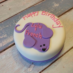 May include: A white cake with purple icing decorated with a purple mouse and the words "Happy Birthday Lulu & French".
