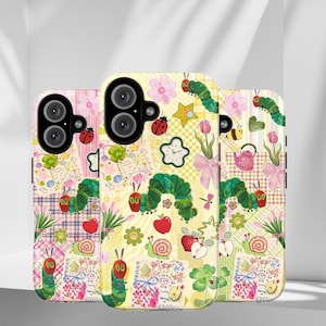 May include: Three colorful phone cases with whimsical designs. Each case features a unique patchwork of illustrations, including a green caterpillar, ladybugs, flowers, and apples. The cases have a glossy finish and are designed to fit a smartphone.