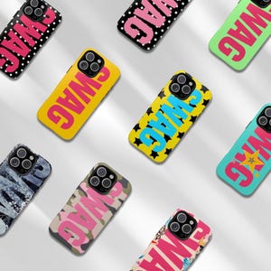 May include: A collection of phone cases with the word "SWAG" in bold, colorful fonts. The cases feature various patterns, including polka dots, stars, camouflage, and graffiti-style designs. The cases are in yellow, black, pink, and blue.