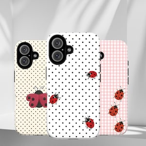 May include: Three phone cases with ladybug designs. One case is cream-colored with black polka dots and a red ladybug. Another is white with black polka dots and red ladybugs. The third is pink gingham with red ladybugs.