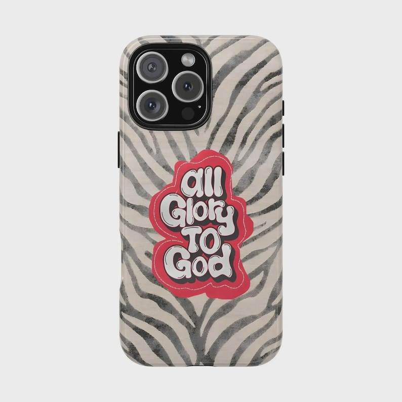 K&ouml;nnte beinhalten: Eine Handyh&uuml;lle mit einem schwarz-wei&szlig;en Zebrastreifenmuster. Auf der H&uuml;lle steht der Text "All Glory To God" in einem rot-wei&szlig;en Design. Die Handyh&uuml;lle hat ein Kameramodul mit drei Objektiven.