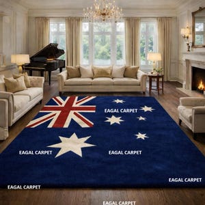 Op de afbeelding: Een groot, rechthoekig blauw tapijt met het Australische vlagontwerp in een woonkamer. Het tapijt heeft de Union Jack in de linkerbovenhoek en witte sterren. De tekst "EAGAL CARPET" is op het tapijt gedrukt.