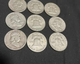 May include: A collection of nine silver-colored United States half dollar coins arranged in a grid. The coins feature the profile of Benjamin Franklin on the obverse and the Liberty Bell on the reverse, with various dates visible on the coin faces.