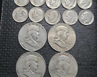 Pode incluir: Uma coleção de moedas de prata, incluindo moedas de dez centavos e meio dólares, dispostas sobre uma superfície escura. As moedas apresentam retratos e inscrições, com datas visíveis. A composição mostra várias denominações e designs históricos.