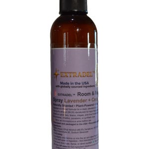 May include: A brown plastic spray bottle with a black nozzle and a label featuring the text EXTRADEL, Room & Fabric Spray, Lavender + Cedar. The label includes information about the plant-powered, naturally scented formula made in the USA.
