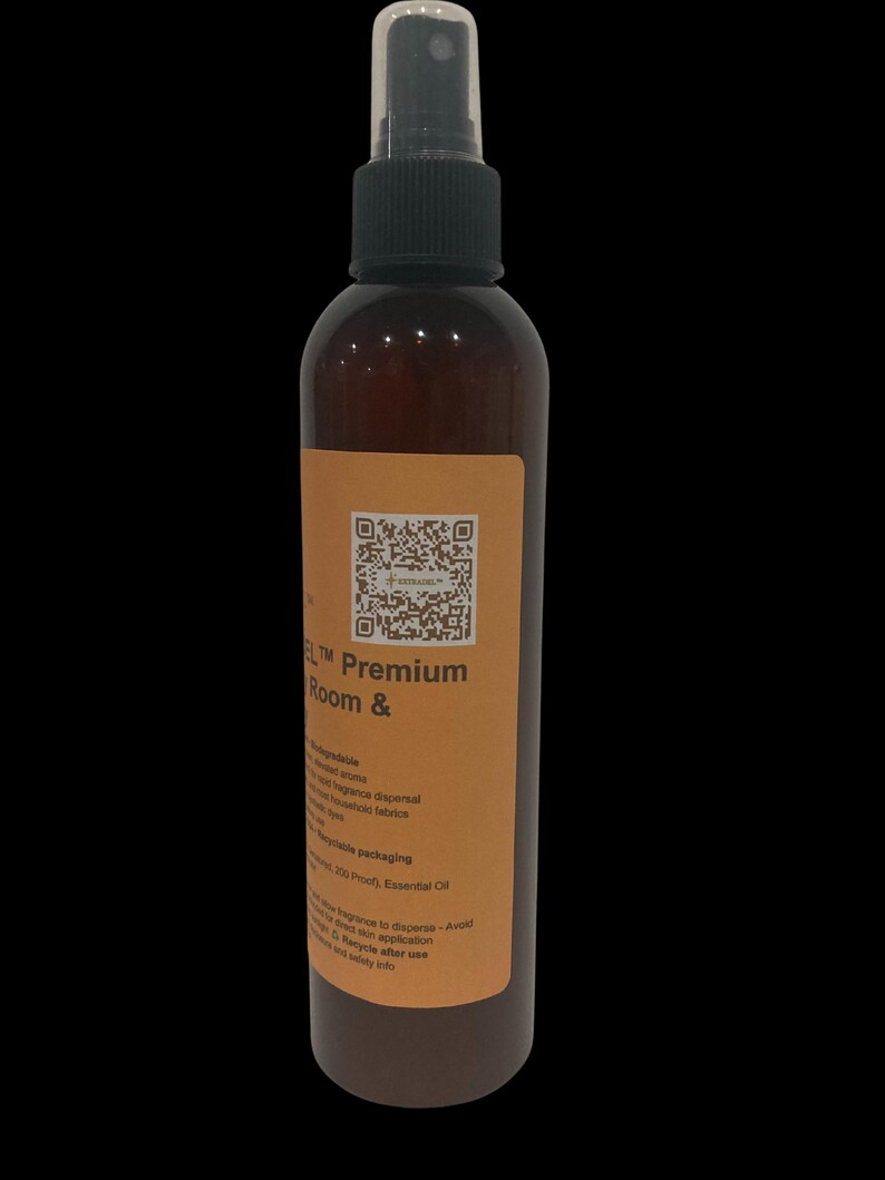 May include: A brown spray bottle with a black cap and a label. The label has text that reads "Premium Room &" and a QR code. The bottle contains a liquid and is designed for room fragrance dispersal.