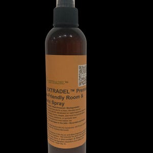 May include: A brown spray bottle with a black nozzle and a white cap. The label reads "EXTRADEL" and "Premium Fabric Spray". The bottle contains a liquid and is designed for use in rooms and on fabrics. The product is plant-powered and biodegradable.