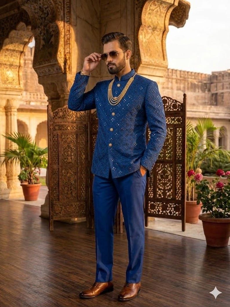Puede incluir: Un conjunto formal para hombre con una chaqueta azul marino bordada con botones dorados, pantalones a juego y un collar dorado de varias capas. El atuendo se completa con zapatos de cuero marr&oacute;n y gafas de sol. El fondo incluye detalles arquitect&oacute;nicos y plantas en macetas.