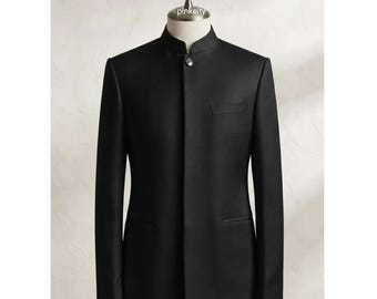 Puede incluir: Un blazer negro liso con cuello mao, un solo botón visible en el escote y una tapeta frontal oculta. La chaqueta incluye un bolsillo en el pecho y dos bolsillos inferiores, exhibida en un maniquí con el texto pinkeity.