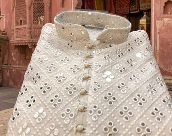 May include: White, embroidered kurta with mirror work. The collarless shirt features a button-down front and a geometric pattern of small mirrors. The text "PINKCITY" is visible at the bottom of the garment.