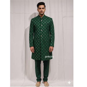 May include: A green suit with a patterned design. The suit includes a long coat with a mandarin collar and matching pants. The coat features a repeating silver floral pattern and silver buttons. The brand name "pinkcity" is visible on the coat.