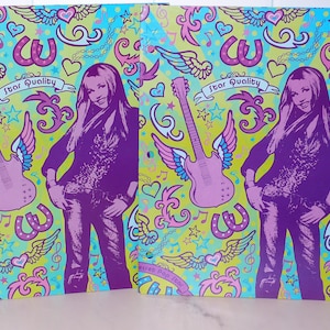 May include: Two matching binders with a colorful design. The design features a purple figure, winged guitars, horseshoes, hearts, and stars on a light green and blue background. The text "Star Quality" is visible.