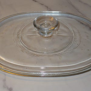 May include: A handmade, wooden serving tray with a natural finish. The tray features a rectangular shape with rounded corners and raised edges. It is designed with two handles for easy carrying. The wood grain is visible throughout the tray.