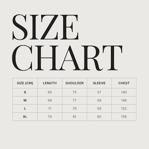 May include: A size chart with the text "SIZE CHART" in large, bold letters. The chart lists sizes S, M, L, and XL, with corresponding measurements in centimeters for length, shoulder, sleeve, and chest.