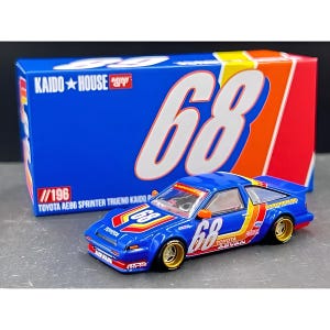 May include: A blue Toyota AE86 Sprinter Trueno Kaido House diecast model car with the number 68 in white. The car has gold wheels and red, yellow, and orange accents. The box behind the car is blue with the number 68 and the Kaido House logo.