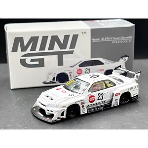 Könnte beinhalten: Ein weißes Nissan LB-ER34 Super Silhouette Modellauto mit schwarzen Rädern und roten Akzenten. Das Auto hat die Nummer 23 und steht vor einer Box mit der Aufschrift "MINI GT".
