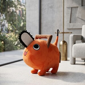 May include: An orange plush toy shaped like a cartoon dog with a chainsaw head. The toy has large black and white eyes, a smiling mouth, and a brown handle. The dog has four small legs and a tail. The toy is sitting on a light-colored floor.