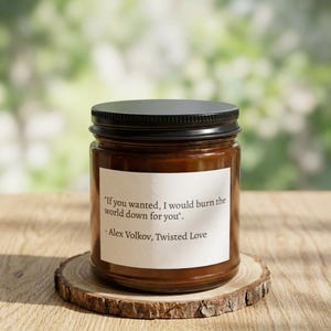 Peut inclure: Une bougie parfumée marron dans un bocal en verre avec un couvercle noir. L'étiquette indique "If you wanted, I would burn the world down for you." par Alex Volkov, Twisted Love. La bougie repose sur un dessous de verre en bois.