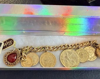 Bracciale con ciondolo a moneta firmato Carol Dauplaise Ltd • Monete del mondo • Ciondolo con pietra rossa • Etichetta originale