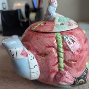 May include: A white ceramic mug with a black handle and the text "But First, Coffee" in a handwritten style. The mug is on a white surface. The mug is 4 inches tall.