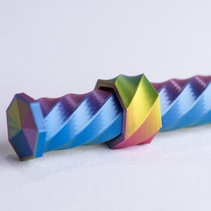 May include: A colorful, geometric kaleidoscope with a spiral design. The kaleidoscope features a vibrant array of colors, including blue, purple, green, yellow, and pink. The object is cylindrical and has a textured surface.