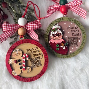 May include: Two round wooden Christmas ornaments with red and white gingham bows and wooden beads. One features a gingerbread man, the other Mrs. Claus. Both have the text "Scan to track Santa" with a QR code and "cookies for santa" text.