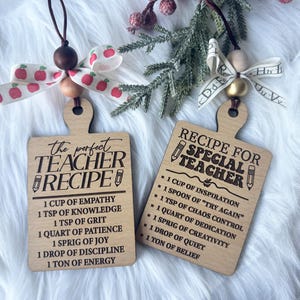 May include: Two rectangular wooden ornaments shaped like cutting boards. One reads THE PERFECT TEACHER RECIPE with ingredients like empathy and patience. The other reads RECIPE FOR SPECIAL TEACHER with ingredients like inspiration and chaos control.
