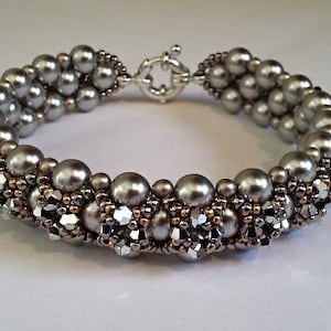 May include: A silver and gray beaded bracelet with a silver clasp. The beads are arranged in a pattern of alternating silver and gray beads.