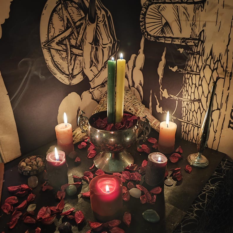 K&ouml;nnte beinhalten: Eine mystische Szene mit brennenden Kerzen in verschiedenen Farben, darunter Rot, Orange und Gr&uuml;n, angeordnet mit getrockneten Rosenbl&auml;ttern und Steinen. Eine silberne Schale enth&auml;lt Kerzen, mit okkulten Symbolen im Hintergrund.