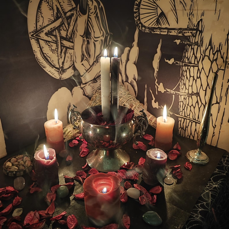 May include: A mystical scene featuring lit candles of various sizes and colors, including red, orange, and white. A silver bowl holds burning candles and is surrounded by red rose petals. The background includes a pentagram and other occult symbols.
